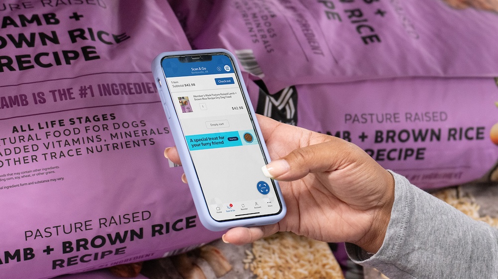 A woman uses the Sam's Club Scan and Go app to scan a bag of dog food.